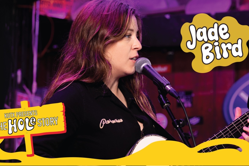 Jade Bird playing guitar and singing into a microphone